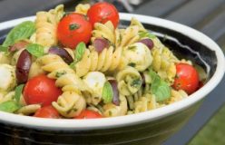 Cold pasta salad with tomatoes, bocconcini and basil dressing